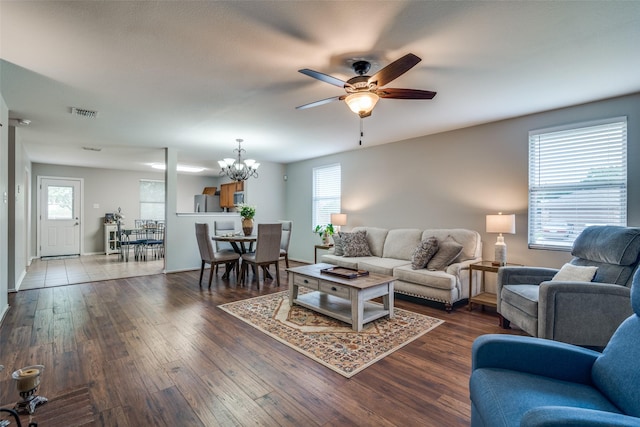 living room featuring baseboards, a healthy amount of sunlight, ceiling fan with notable chandelier, and wood finished floors