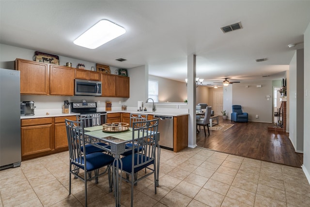 kitchen featuring visible vents, ceiling fan, light countertops, brown cabinets, and stainless steel appliances