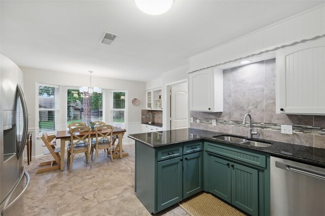 kitchen with visible vents, green cabinetry, a sink, appliances with stainless steel finishes, and a notable chandelier
