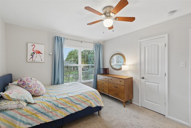 bedroom featuring baseboards, a ceiling fan, and light colored carpet