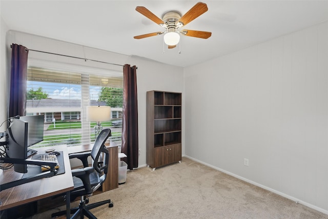 home office with baseboards, ceiling fan, and light colored carpet