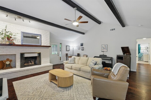 living area featuring visible vents, a brick fireplace, hardwood / wood-style floors, ceiling fan, and vaulted ceiling with beams
