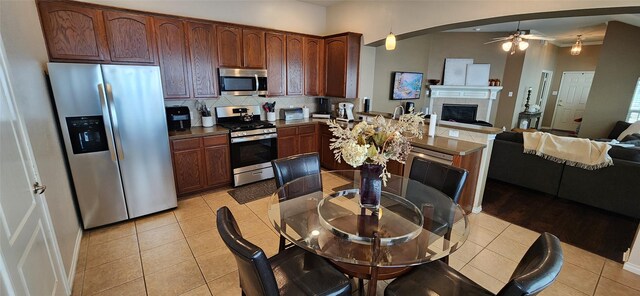 kitchen with stainless steel appliances, open floor plan, decorative backsplash, and a peninsula