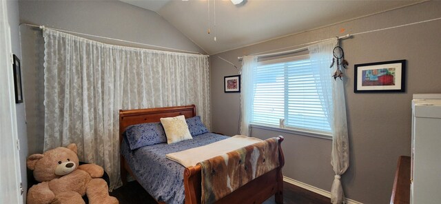 bedroom featuring baseboards, lofted ceiling, and wood finished floors