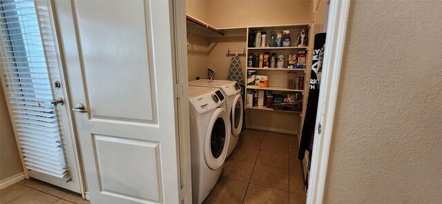laundry room featuring a textured wall, washer and clothes dryer, and tile patterned flooring