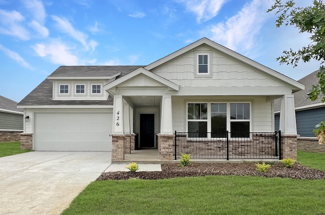 craftsman inspired home featuring a garage, a front lawn, covered porch, and driveway
