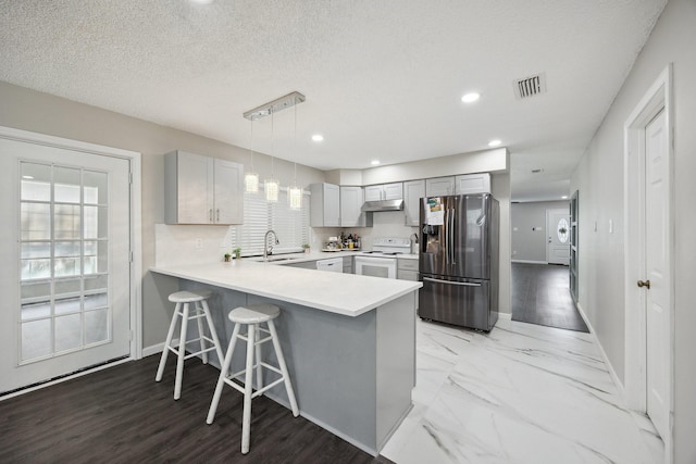 1706 Delaford Cir, Carrollton, TX 75007 - kitchen featuring a peninsula, baseboards, stainless steel refrigerator with ice dispenser, white range with electric stovetop, and gray cabinetry