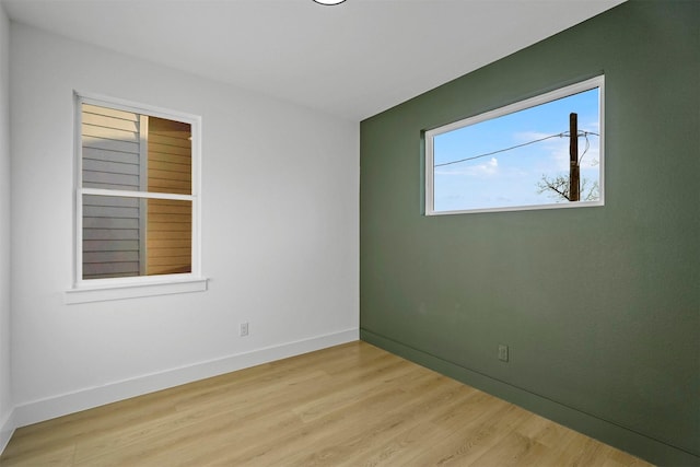 spare room featuring light wood-style floors and baseboards