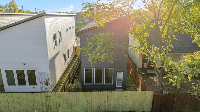 back of house with a fenced backyard