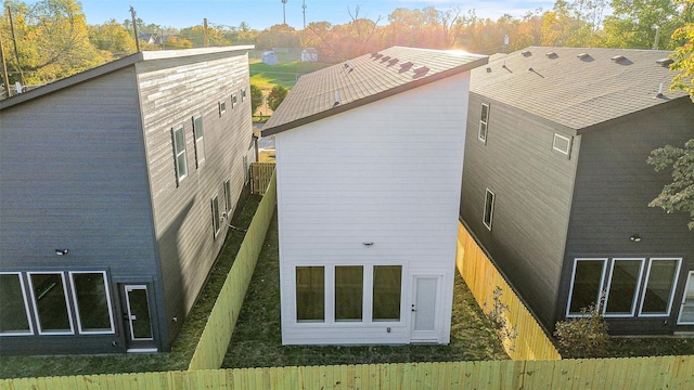 rear view of house featuring a fenced backyard