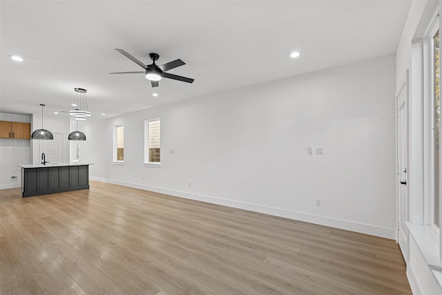 unfurnished living room with recessed lighting, a ceiling fan, and light wood-style floors