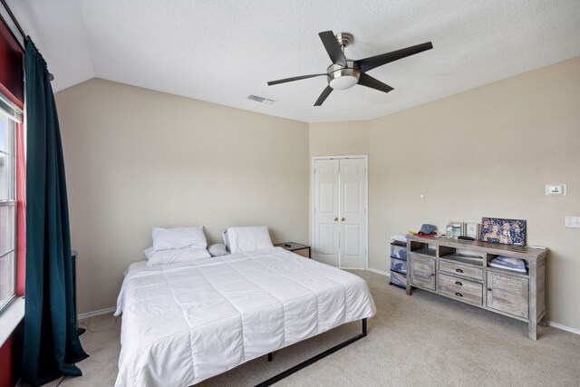 bedroom with ceiling fan, light colored carpet, visible vents, baseboards, and a closet