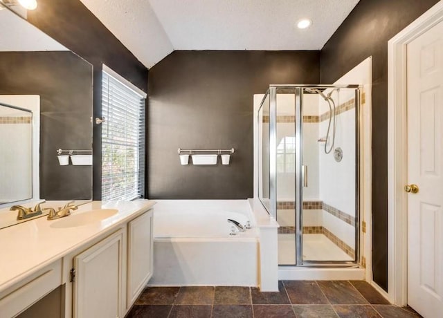 bathroom featuring a garden tub, stone finish flooring, vaulted ceiling, a stall shower, and vanity