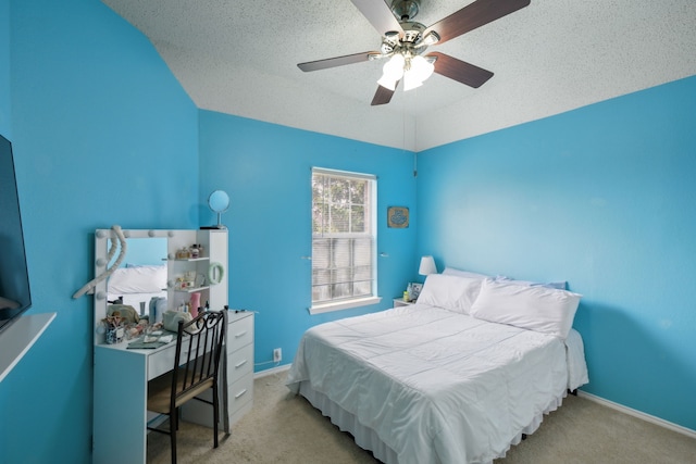 carpeted bedroom with a textured ceiling, vaulted ceiling, and ceiling fan