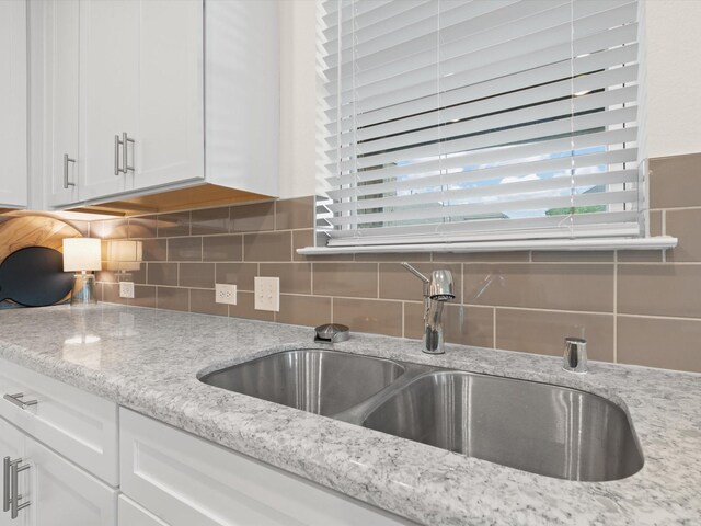 3601 Keechi Creek Dr, Celina, TX 75078 - kitchen featuring white cabinetry, light stone counters, tasteful backsplash, and a sink