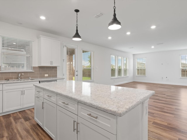 3601 Keechi Creek Dr, Celina, TX 75078 - kitchen with a center island, a sink, pendant lighting, dark wood-style flooring, and backsplash