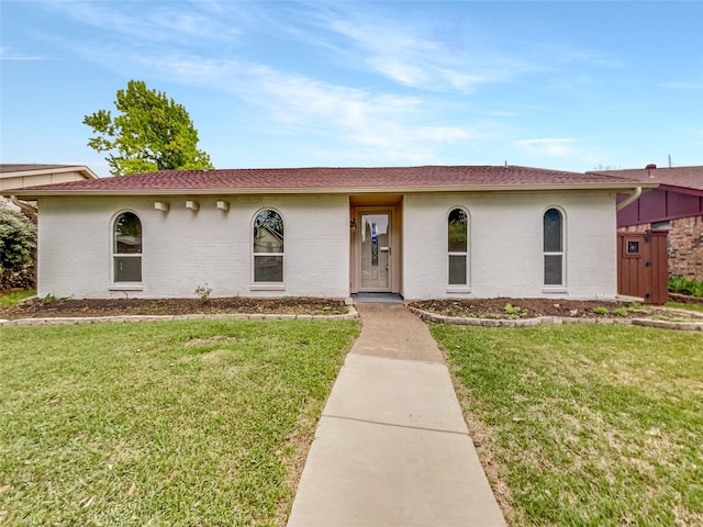 view of front of house with brick siding and a front lawn