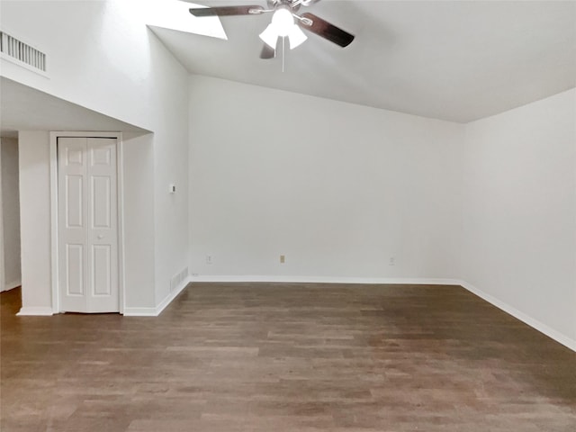 spare room with baseboards, a ceiling fan, arched walkways, and wood finished floors