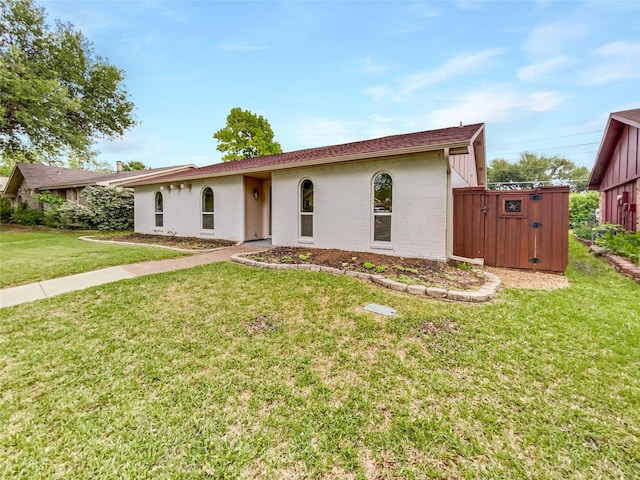 ranch-style house featuring a front lawn and brick siding