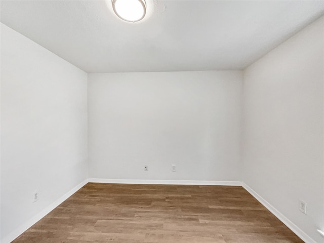 unfurnished room with baseboards and wood finished floors