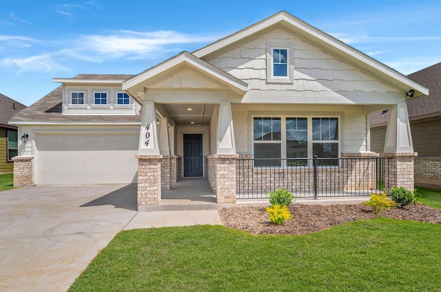 craftsman-style home featuring covered porch, driveway, and a front yard