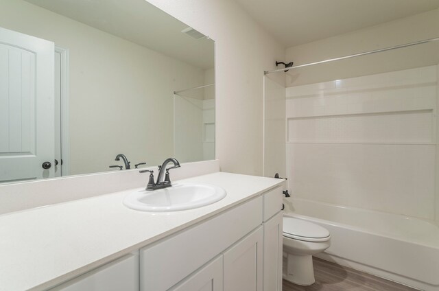 full bathroom featuring visible vents, wood finished floors, vanity, toilet, and  shower combination