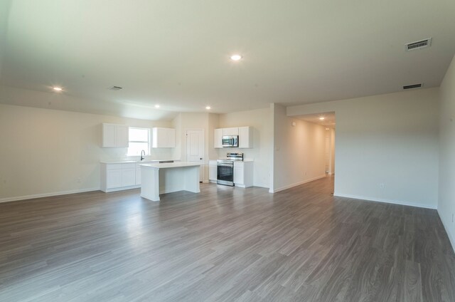 unfurnished living room with recessed lighting, baseboards, visible vents, and wood finished floors