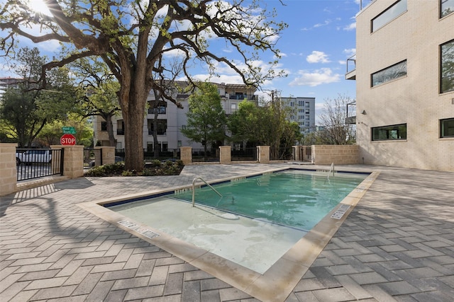 community pool with fence and a patio