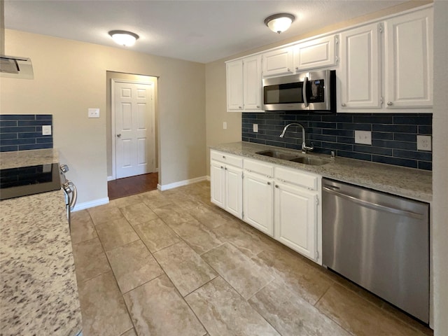 kitchen with white cabinets, stainless steel appliances, decorative backsplash, and a sink