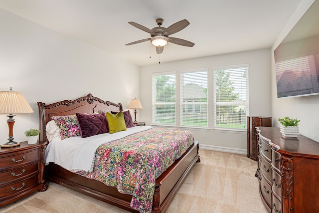 bedroom with baseboards, ceiling fan, and light carpet