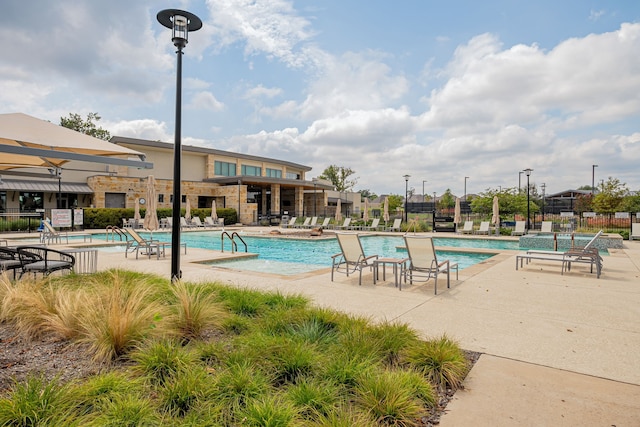 community pool featuring a patio and fence