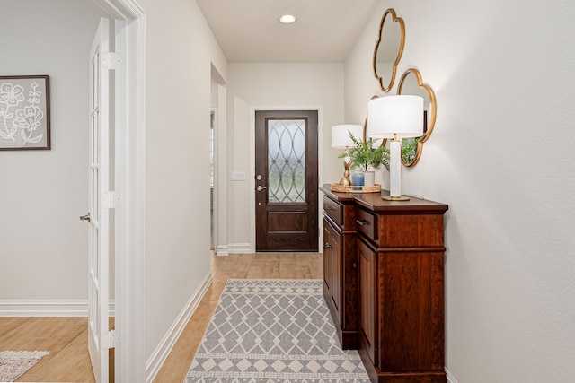 doorway to outside featuring baseboards, recessed lighting, and light wood-style flooring