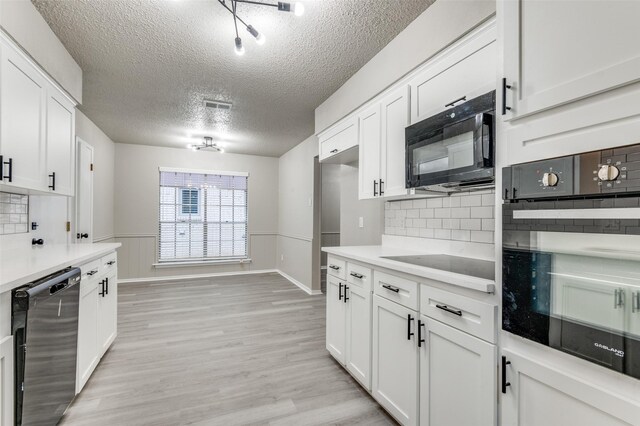 kitchen featuring light countertops, white cabinetry, black appliances, and tasteful backsplash