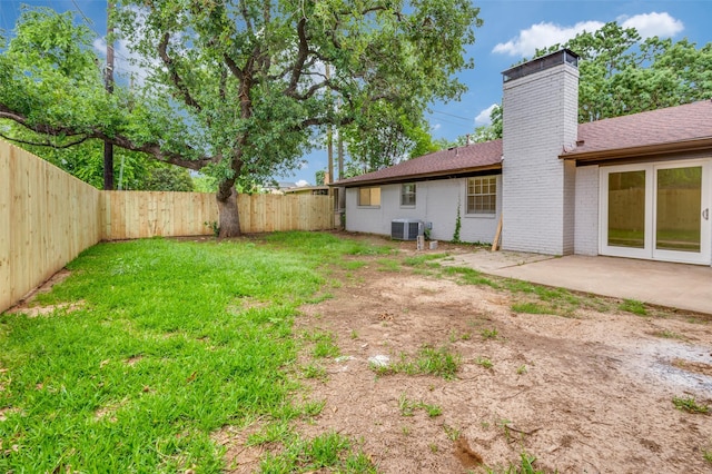 view of yard with central AC unit, a patio area, and a fenced backyard