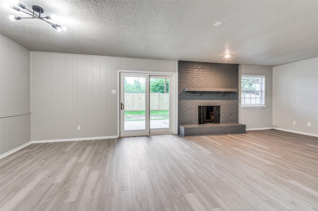 unfurnished living room featuring plenty of natural light, a textured ceiling, and wood finished floors