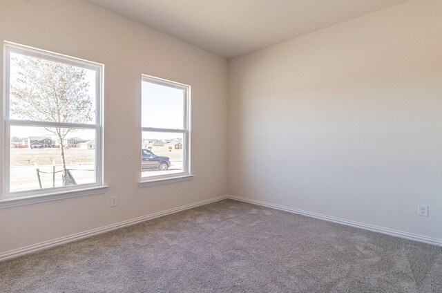 unfurnished room featuring carpet flooring and baseboards