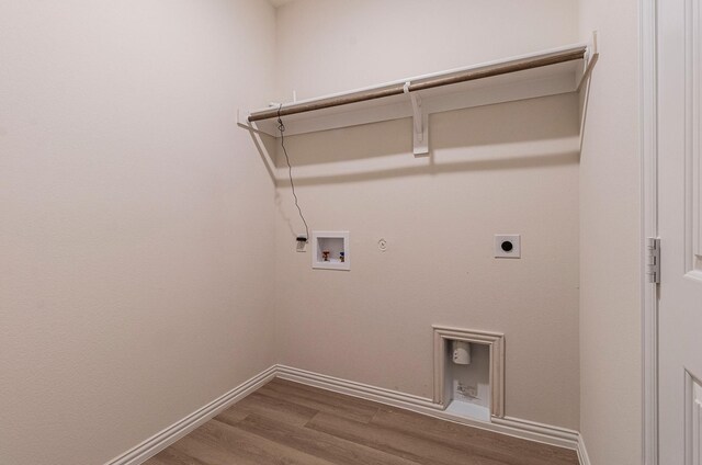 laundry area featuring electric dryer hookup, hookup for a gas dryer, wood finished floors, baseboards, and hookup for a washing machine