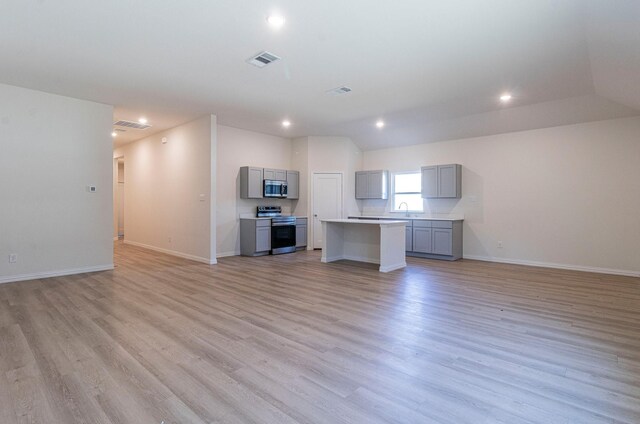 interior space with baseboards, light wood finished floors, and visible vents
