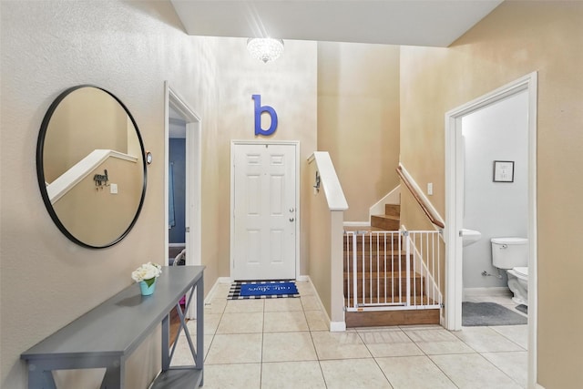 foyer with tile patterned floors, stairs, and baseboards