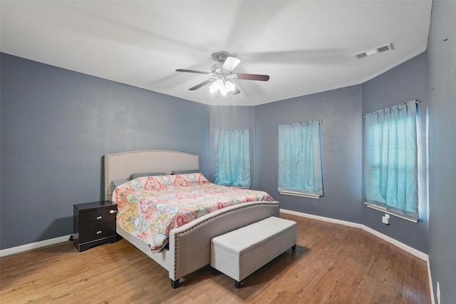 bedroom with wood finished floors, baseboards, and ceiling fan