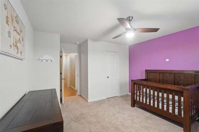 carpeted bedroom featuring baseboards and ceiling fan