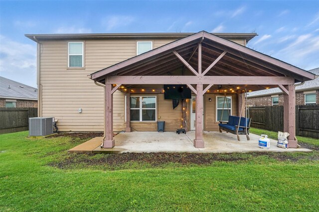 back of property with central AC unit and a patio area