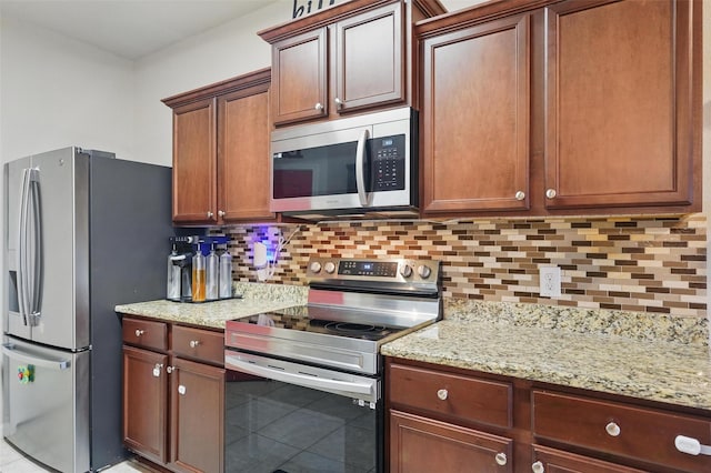 kitchen featuring appliances with stainless steel finishes, tasteful backsplash, and light stone counters