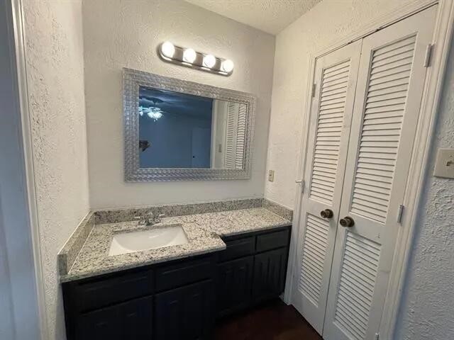 2406 Parkside Dr, Grand Prairie, TX 75052 - bathroom with vanity and a textured wall