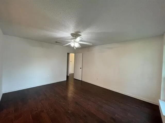 2406 Parkside Dr, Grand Prairie, TX 75052 - empty room with dark wood-type flooring, a textured ceiling, baseboards, and ceiling fan
