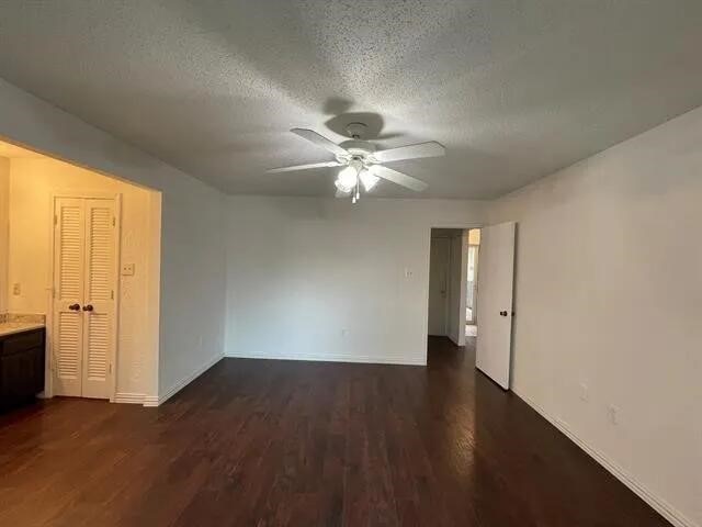 2406 Parkside Dr, Grand Prairie, TX 75052 - interior space with baseboards, a ceiling fan, dark wood-style floors, and a textured ceiling