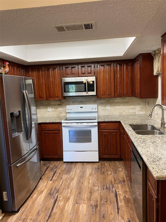 2406 Parkside Dr, Grand Prairie, TX 75052 - kitchen with stainless steel appliances, visible vents, a sink, and wood finished floors