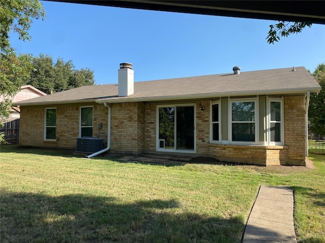 2406 Parkside Dr, Grand Prairie, TX 75052 - back of house featuring brick siding, central AC unit, a yard, and a chimney