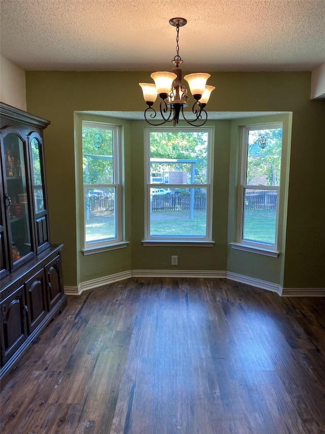 2406 Parkside Dr, Grand Prairie, TX 75052 - unfurnished dining area featuring an inviting chandelier, a textured ceiling, dark wood-style flooring, and a wealth of natural light