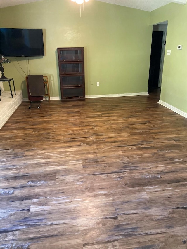 2406 Parkside Dr, Grand Prairie, TX 75052 - unfurnished living room with baseboards, wood finished floors, and lofted ceiling